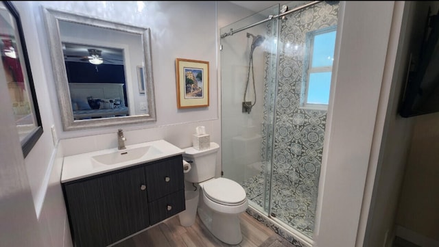 bathroom featuring vanity, toilet, a shower with shower door, and hardwood / wood-style floors