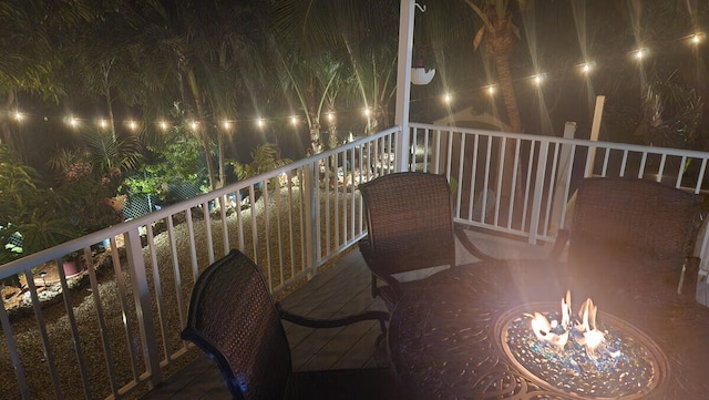 balcony at twilight featuring an outdoor fire pit