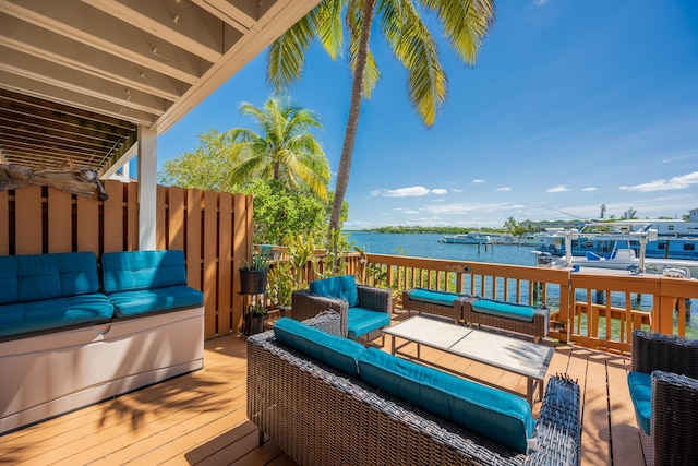 wooden deck with an outdoor hangout area and a water view