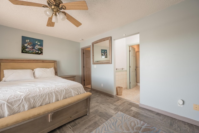 bedroom with ceiling fan, ensuite bath, and a textured ceiling