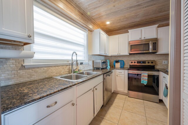 kitchen featuring white cabinetry, stainless steel appliances, sink, and light tile patterned floors