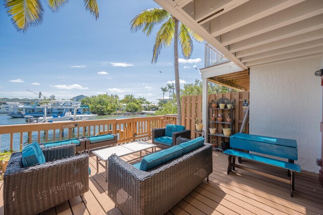 wooden deck featuring a water view and outdoor lounge area