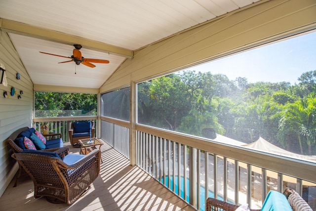 sunroom / solarium featuring lofted ceiling with beams and ceiling fan