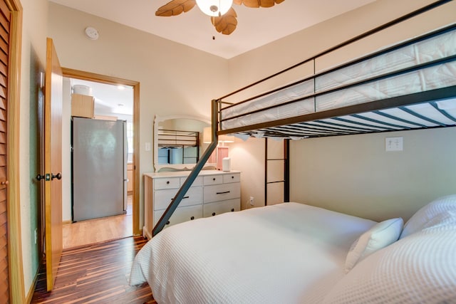 bedroom featuring dark hardwood / wood-style floors and stainless steel fridge