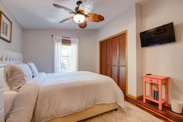 bedroom with dark wood-type flooring, ceiling fan, and a closet