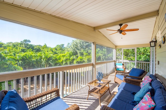 sunroom with lofted ceiling with beams, plenty of natural light, and ceiling fan