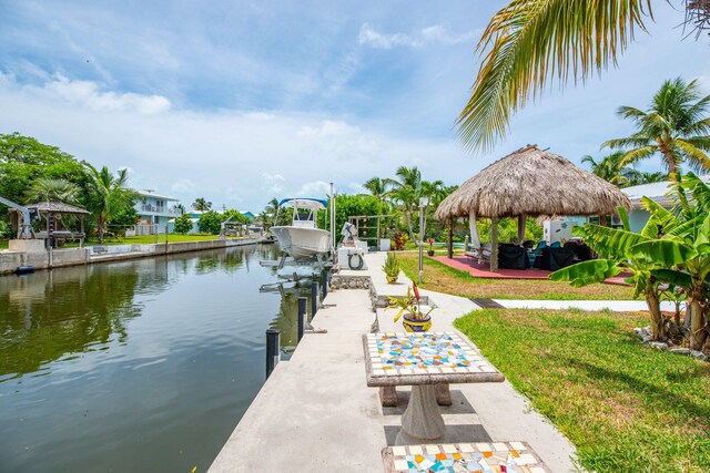 view of dock featuring a gazebo, a lawn, and a water view