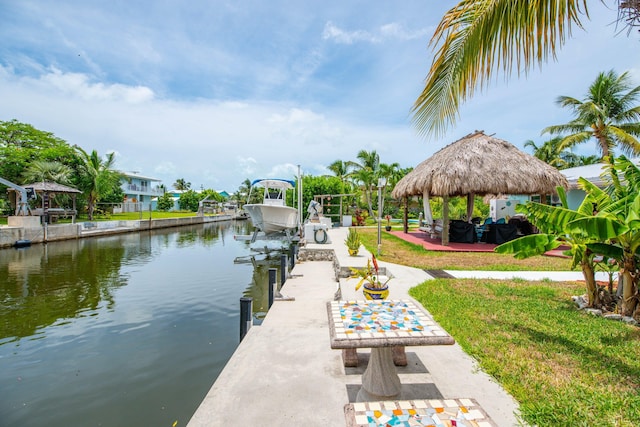 view of dock featuring a gazebo, a lawn, and a water view