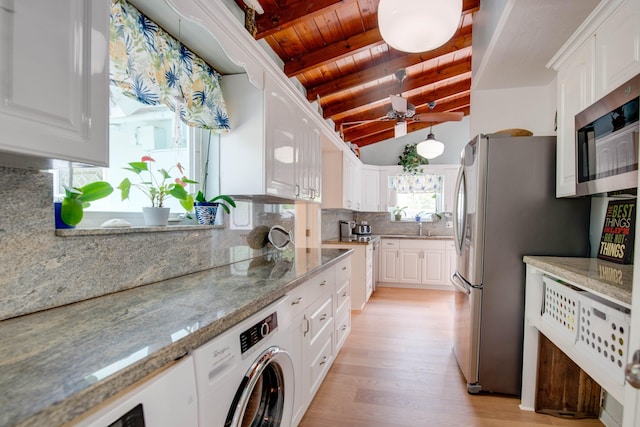 kitchen with stainless steel appliances, washer / dryer, and white cabinets