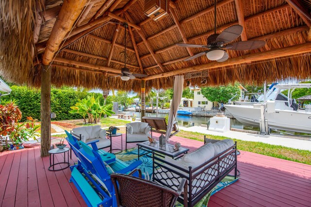 wooden deck featuring an outdoor living space, a gazebo, a water view, and ceiling fan