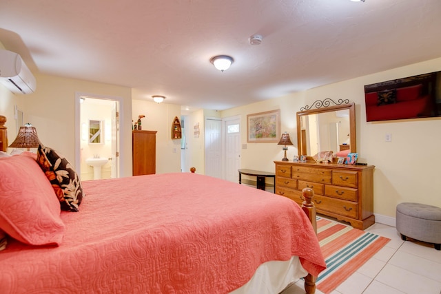 tiled bedroom with a wall mounted air conditioner, ensuite bathroom, and sink