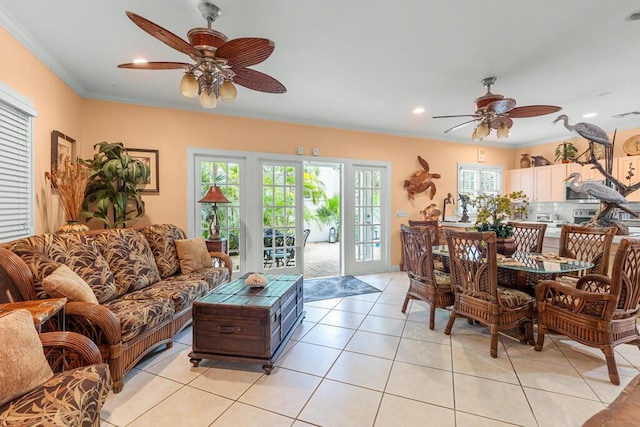 living room featuring light tile patterned floors, ornamental molding, and ceiling fan