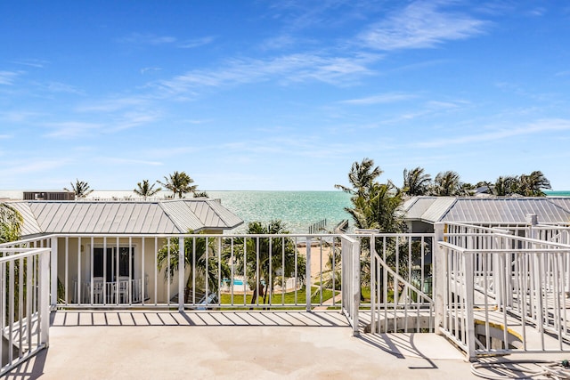 exterior space featuring a balcony and a water view