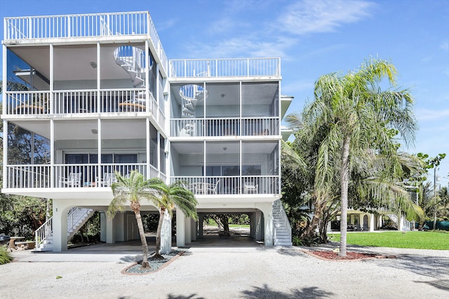 view of property with a carport, stairway, and driveway