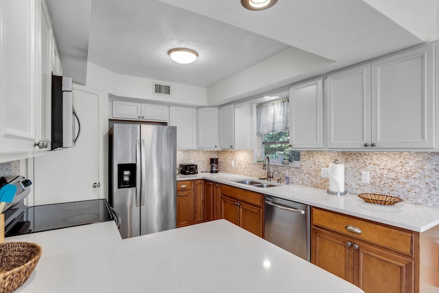 kitchen featuring visible vents, a sink, light countertops, appliances with stainless steel finishes, and backsplash