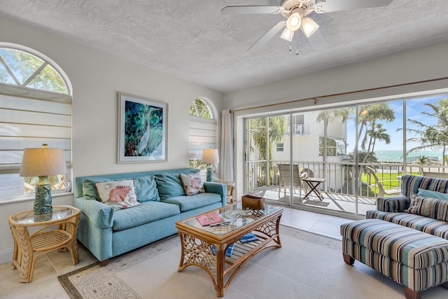 living room featuring ceiling fan and a textured ceiling