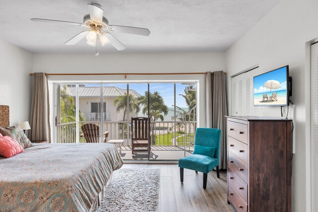 bedroom featuring wood finished floors, access to exterior, and a ceiling fan