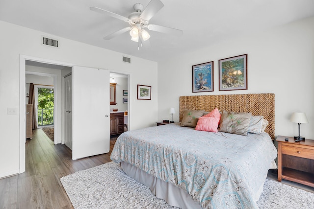 bedroom featuring visible vents, ensuite bath, ceiling fan, and wood finished floors