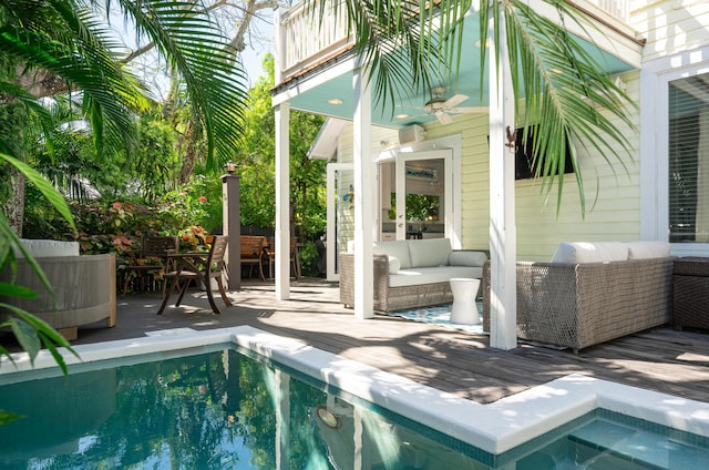 view of pool with outdoor lounge area, ceiling fan, and a deck