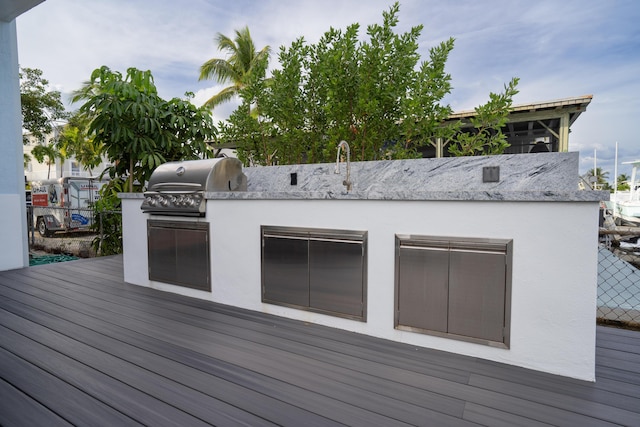 wooden terrace with a grill and area for grilling