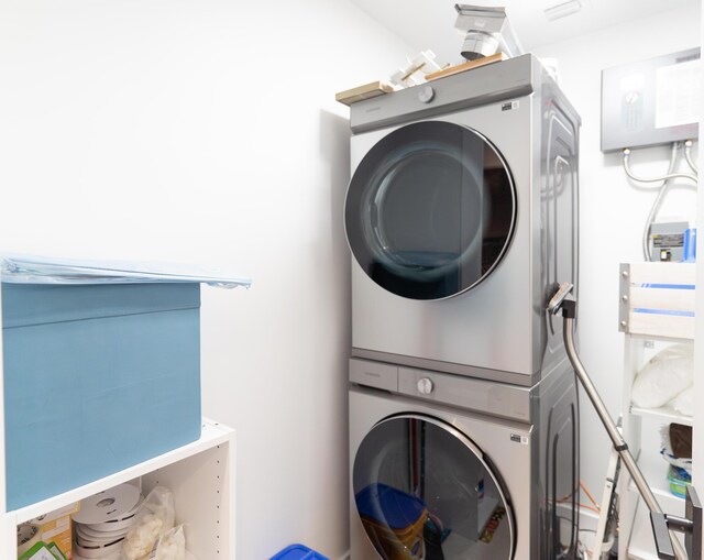 clothes washing area with stacked washer / dryer