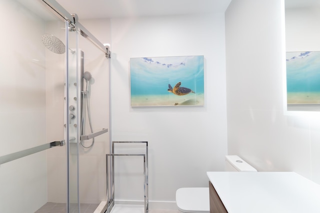 bathroom featuring vanity, an enclosed shower, and toilet