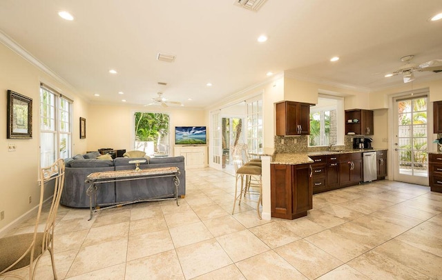 kitchen with stainless steel dishwasher, kitchen peninsula, ceiling fan, and a breakfast bar