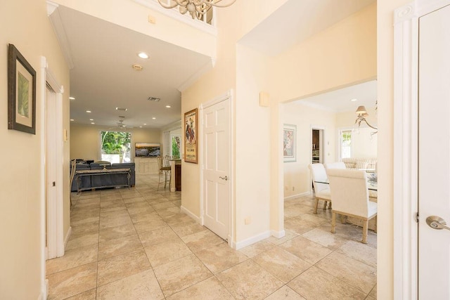 corridor with light tile patterned floors and ornamental molding