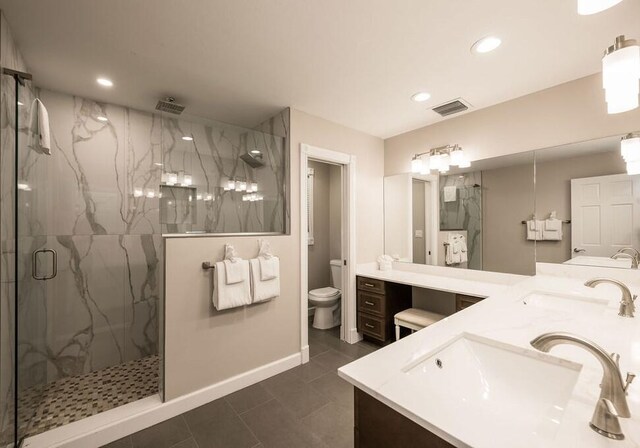 bathroom featuring vanity, toilet, and an enclosed shower