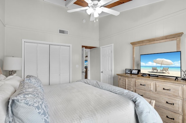 bedroom featuring two closets, ceiling fan, and a towering ceiling