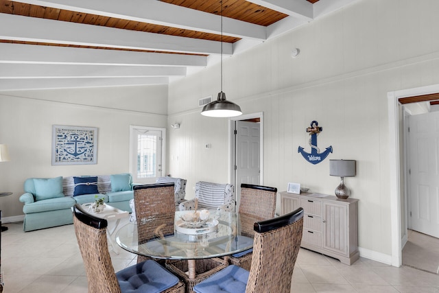 dining room with lofted ceiling with beams and light tile patterned flooring