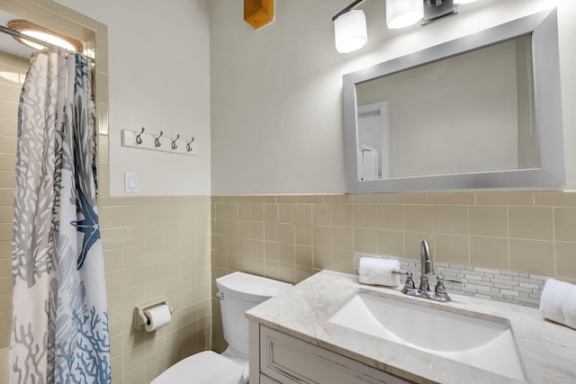 bathroom with vanity, curtained shower, toilet, and tile walls