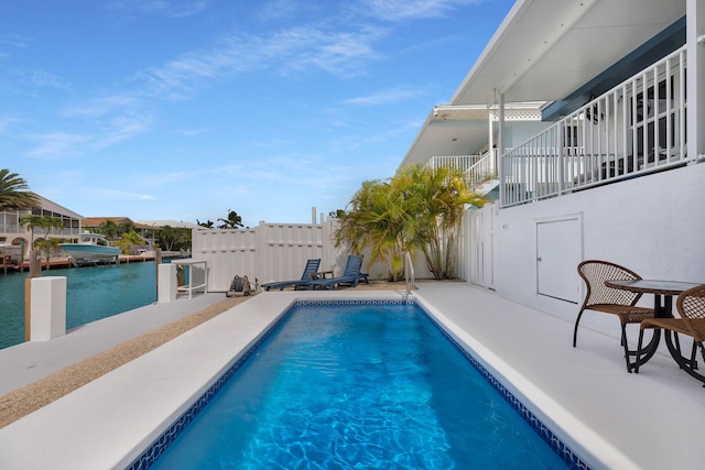 view of swimming pool with a patio and a water view