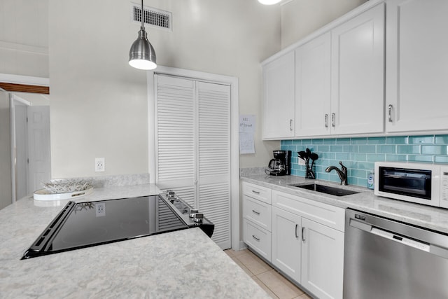 kitchen with decorative light fixtures, white cabinetry, dishwasher, sink, and black cooktop