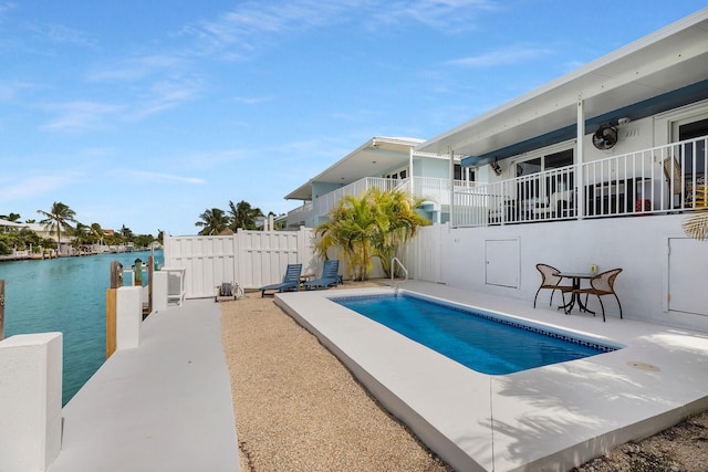 view of swimming pool with a patio and a water view