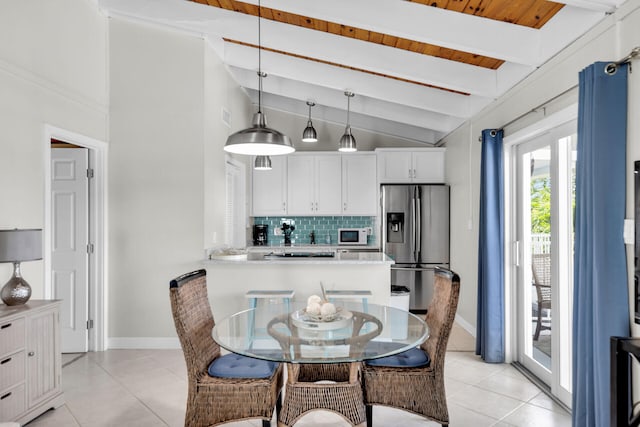 tiled dining room with vaulted ceiling with beams