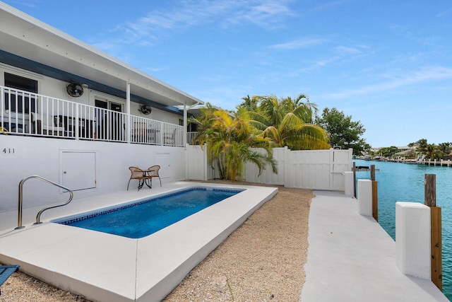 view of swimming pool featuring a water view and a patio