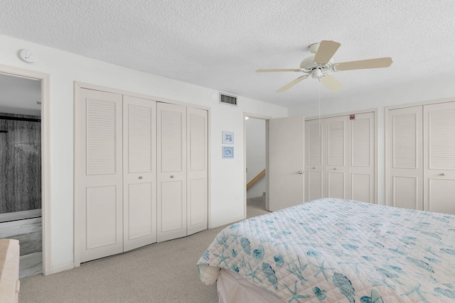 601 W Ocean Dr Unit 411C, Key Colony, FL 33051 - carpeted bedroom featuring two closets, a textured ceiling, and ceiling fan