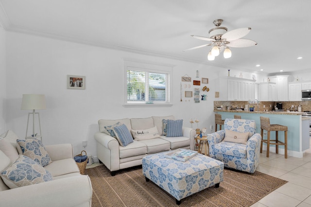 tiled living room with ceiling fan and ornamental molding