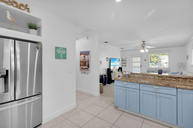 kitchen featuring stone counters, light tile patterned flooring, ornamental molding, ceiling fan, and stainless steel refrigerator with ice dispenser