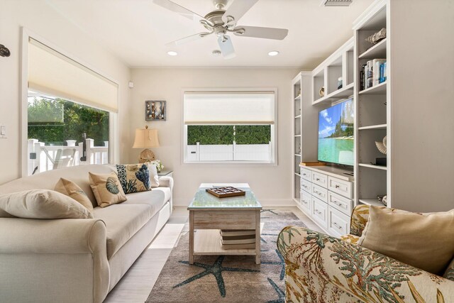 living room with light hardwood / wood-style floors and ceiling fan