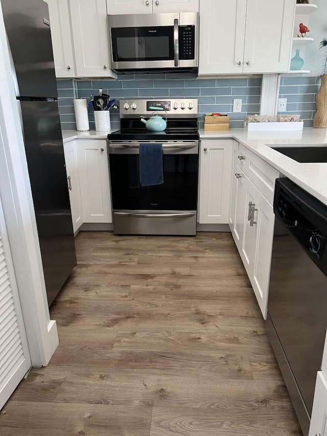 kitchen featuring white cabinetry, stainless steel appliances, and light wood finished floors