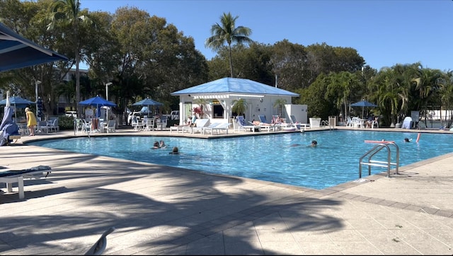 community pool featuring fence and a patio area
