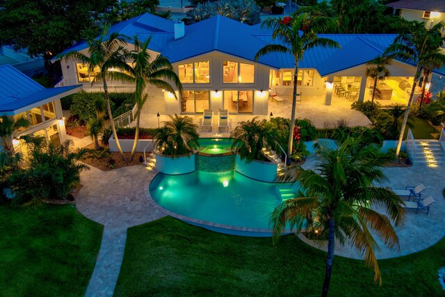 view of pool featuring an in ground hot tub, a patio, and a lawn