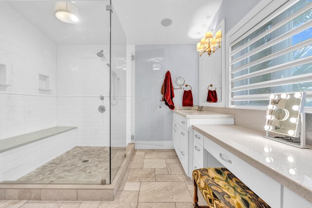 bathroom featuring a shower with door and vanity