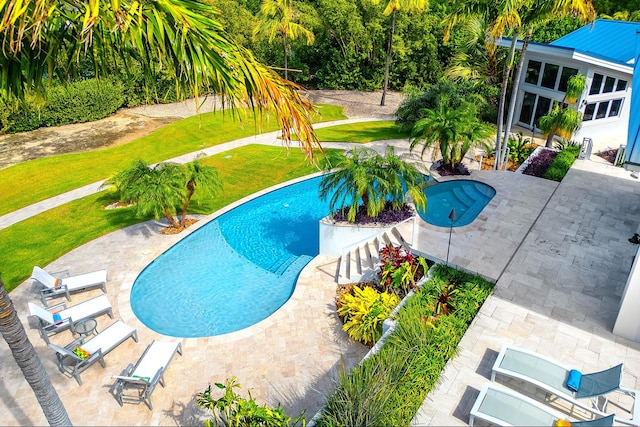 view of pool with a lawn and a patio area