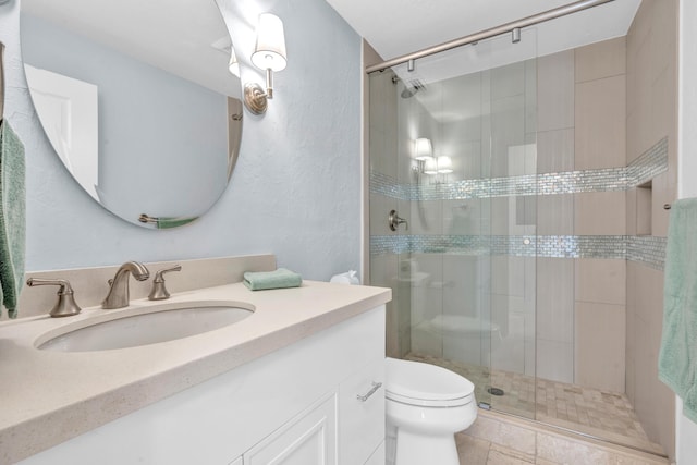 bathroom featuring vanity, a shower with shower door, and toilet