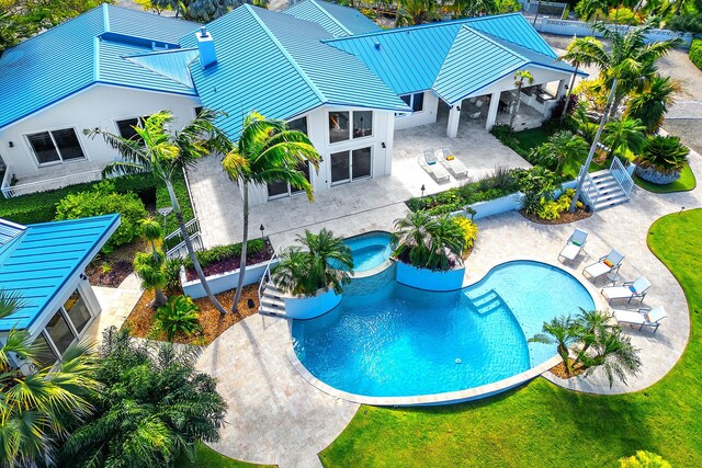 view of swimming pool featuring a patio and an in ground hot tub