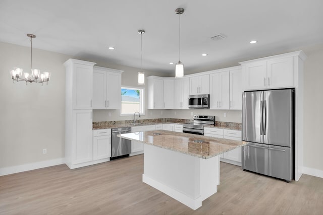 22737 Blackbeard Ln, Cudjoe, FL 33042 - kitchen featuring light wood-style flooring, stainless steel appliances, a sink, visible vents, and white cabinets