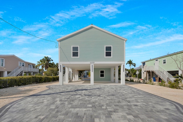 22737 Blackbeard Ln, Cudjoe, FL 33042 - view of front facade featuring a carport, decorative driveway, and stairway
